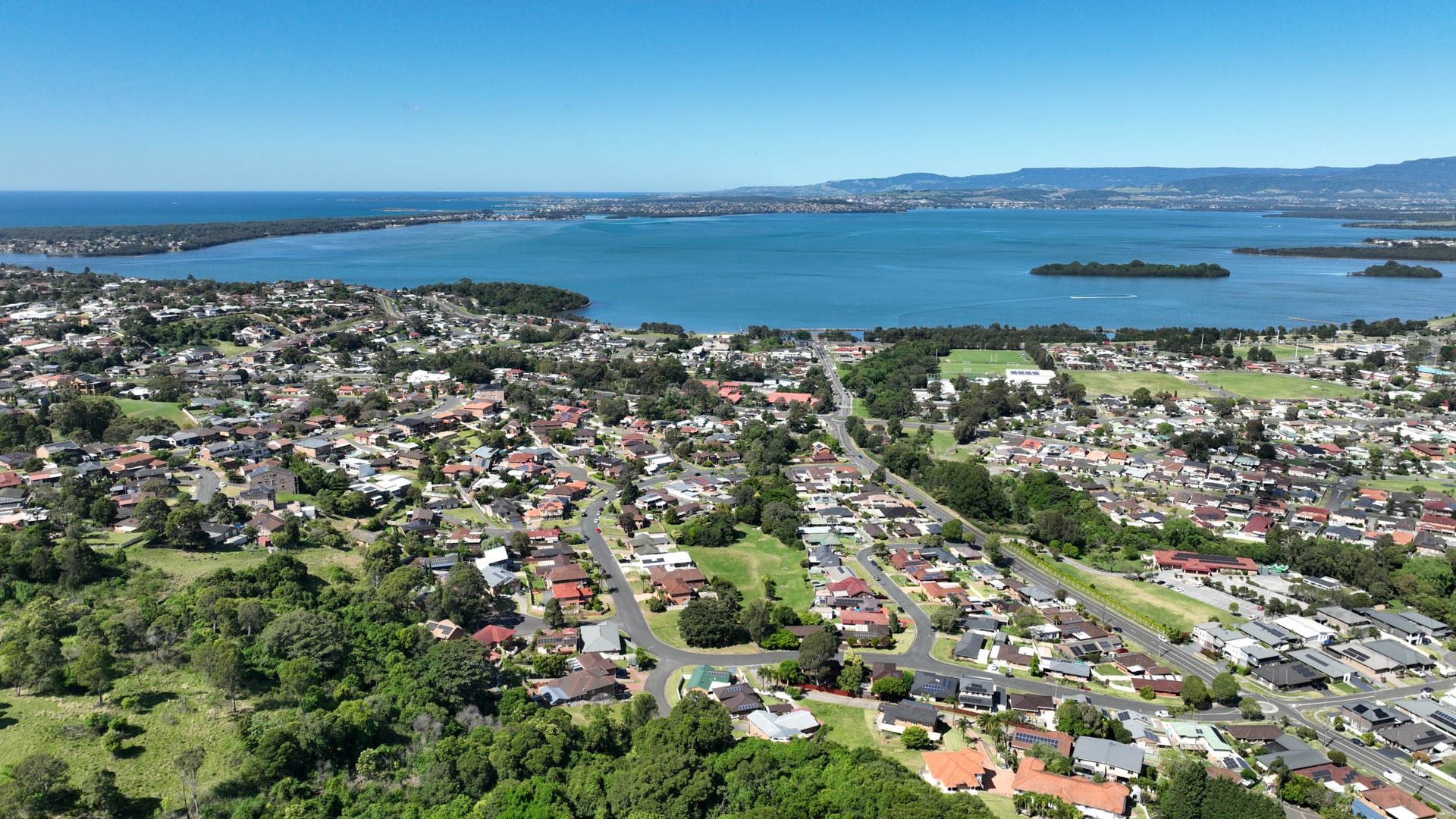 Wide aerial showing Berkeley, Lake Illawarra and the coastline